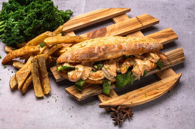 Pan de camarón: pan rústico relleno de camarones al ajillo, lechuga y salsa chipotle, con papas